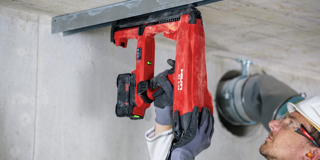 BX 3 battery-powered nailer, a low vibration alternative to drilling, being used to fasten on concrete